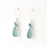 Pair of earrings with blue teardrop stones on a white background