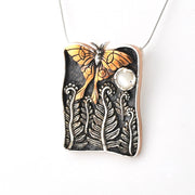 Luna moth pendant on a white background