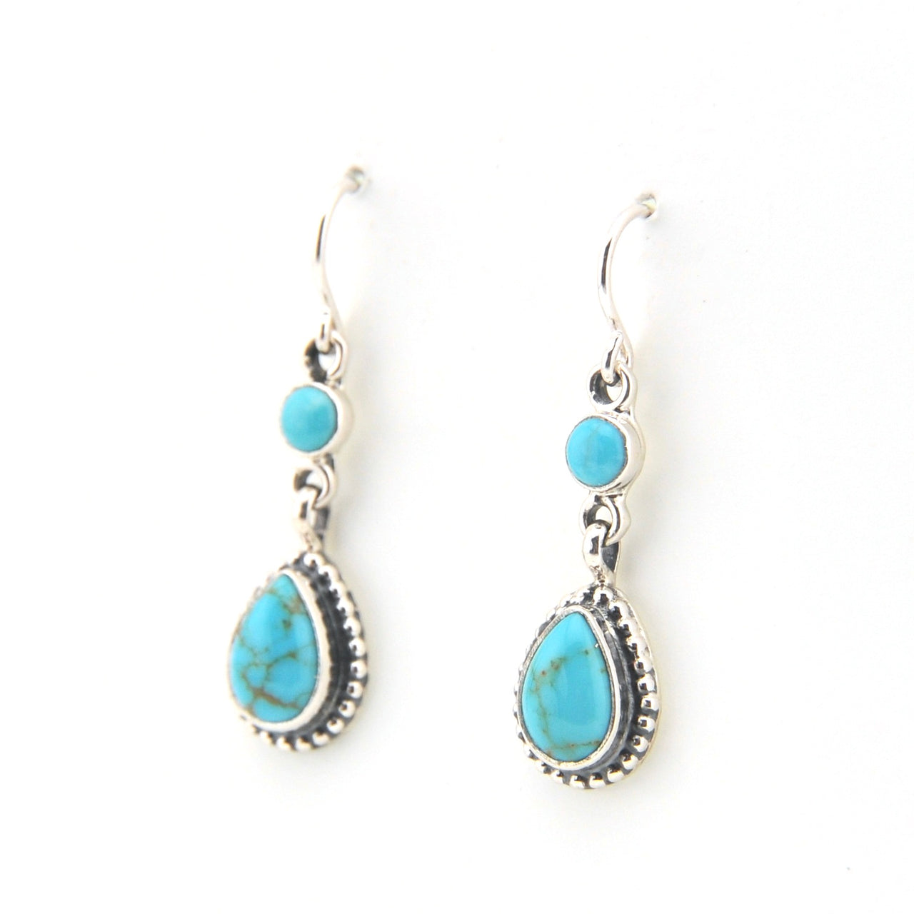 Turquoise teardrop earrings with silver hooks on a white background