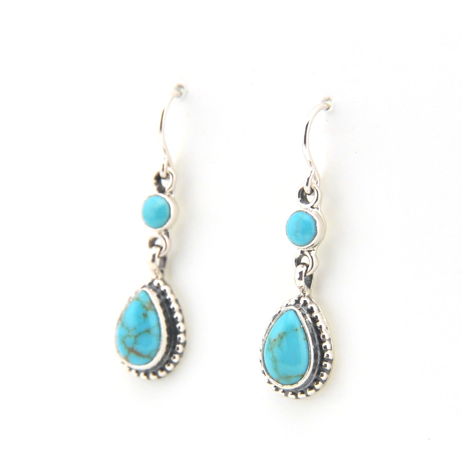 Turquoise teardrop earrings with silver hooks on a white background