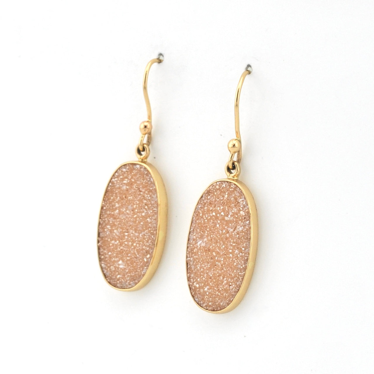 Pair of gold-framed beige druzy earrings on a white background