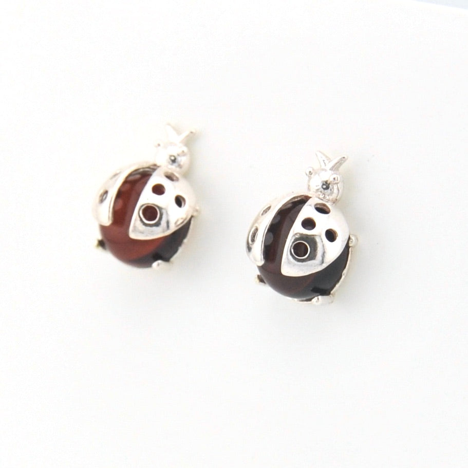 Pair of ladybug-shaped earrings with silver and brown design on a white background