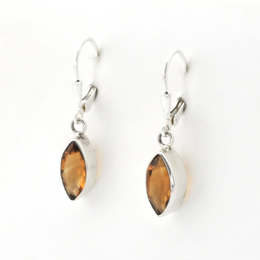 Pair of silver earrings with marquise-shaped amber stones on a white background