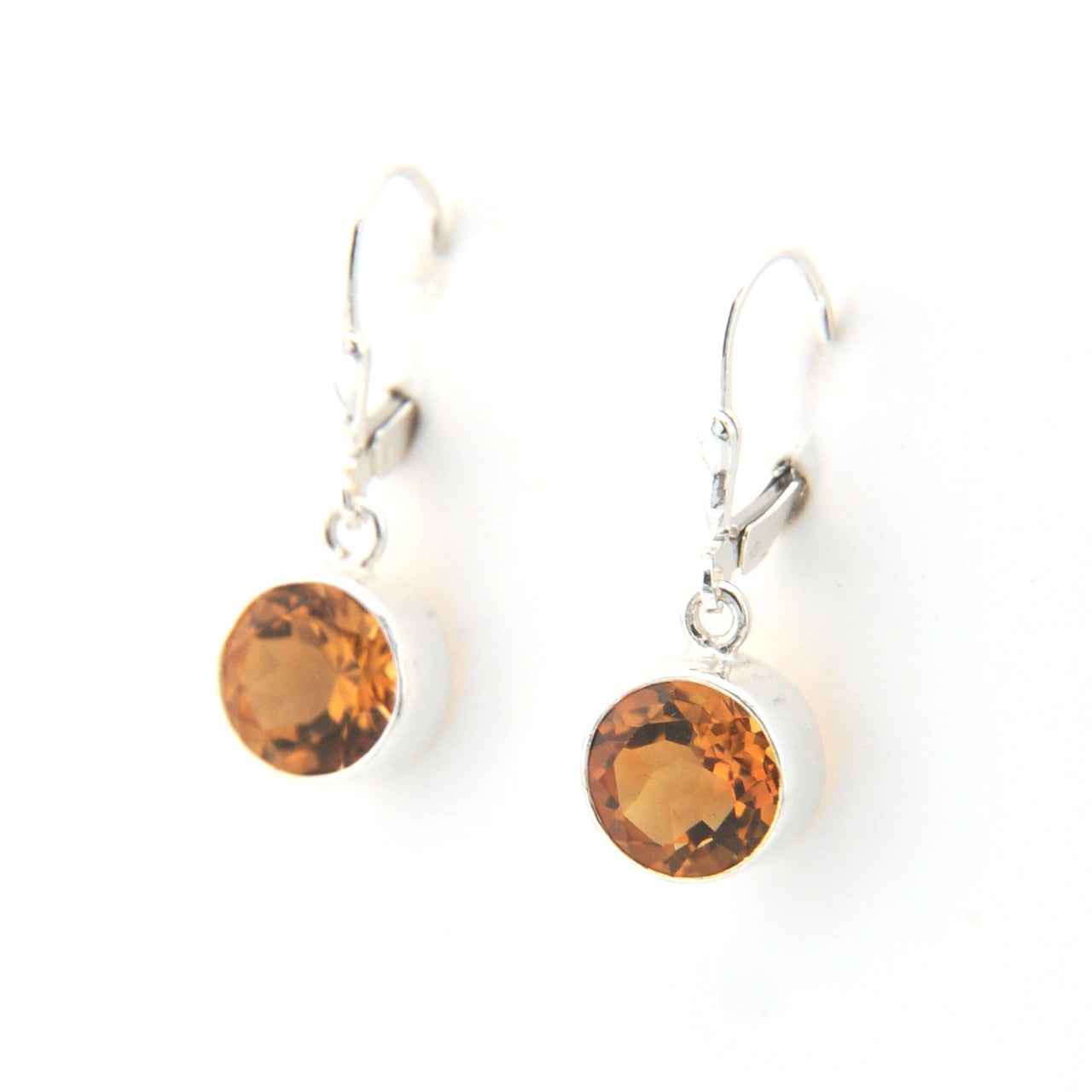 Pair of earrings with amber-colored stones on a white background