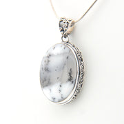 Silver pendant with a white stone on a white background