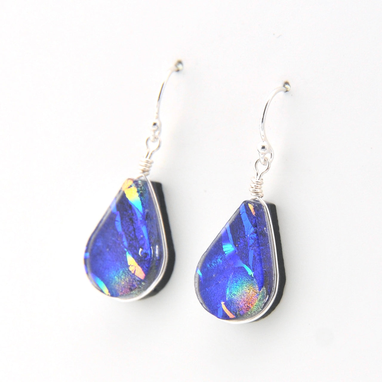 Teardrop-shaped blue iridescent earrings on a white background