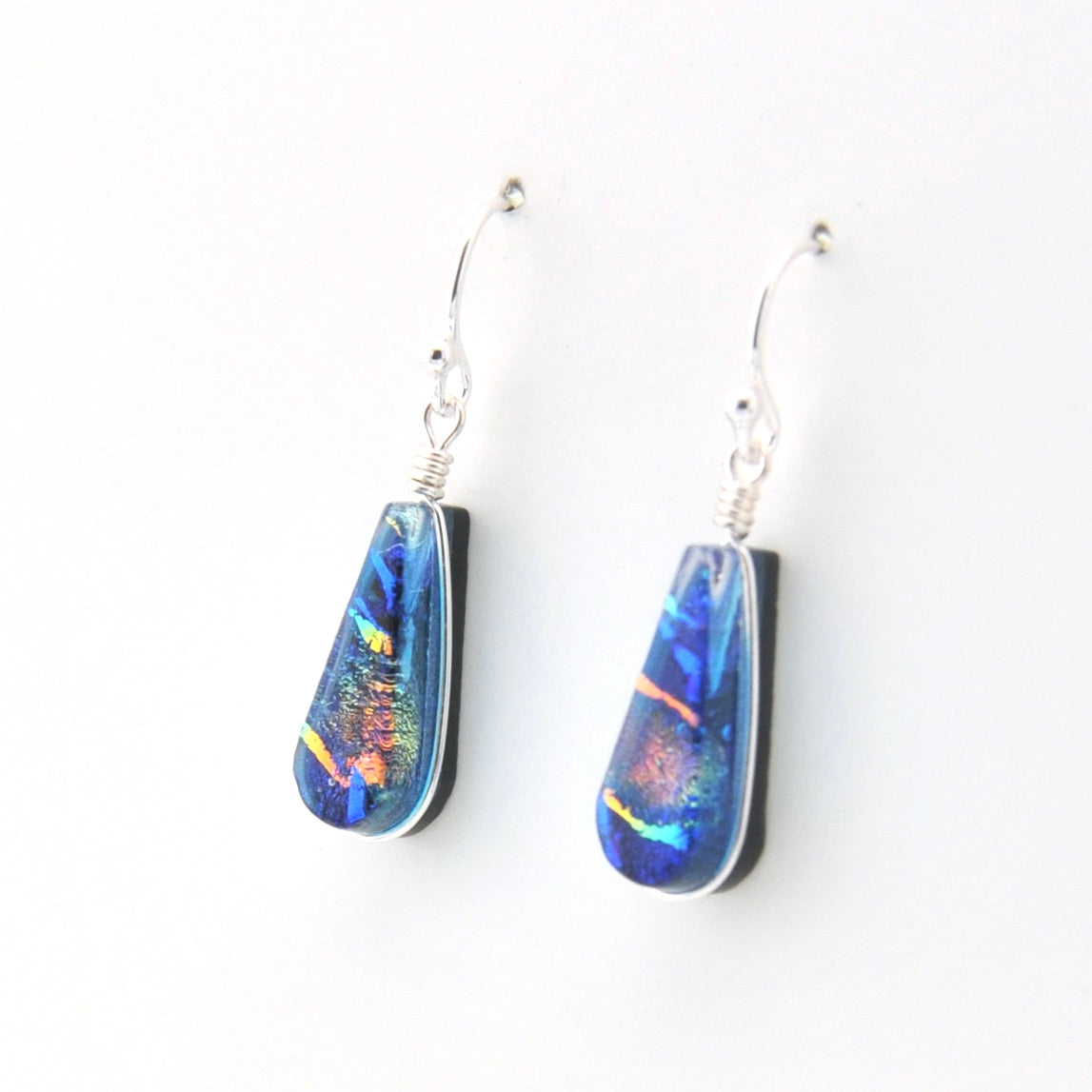 Teardrop-shaped opal earrings on a white background