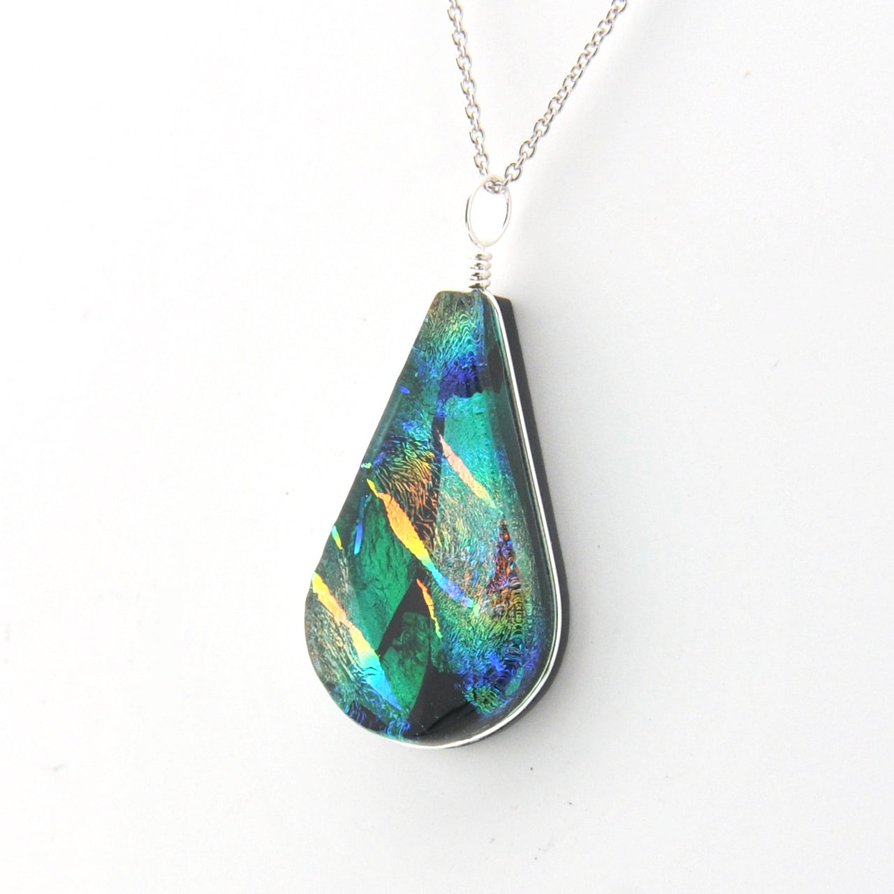 Teardrop-shaped pendant with multicolored iridescent finish on a white background