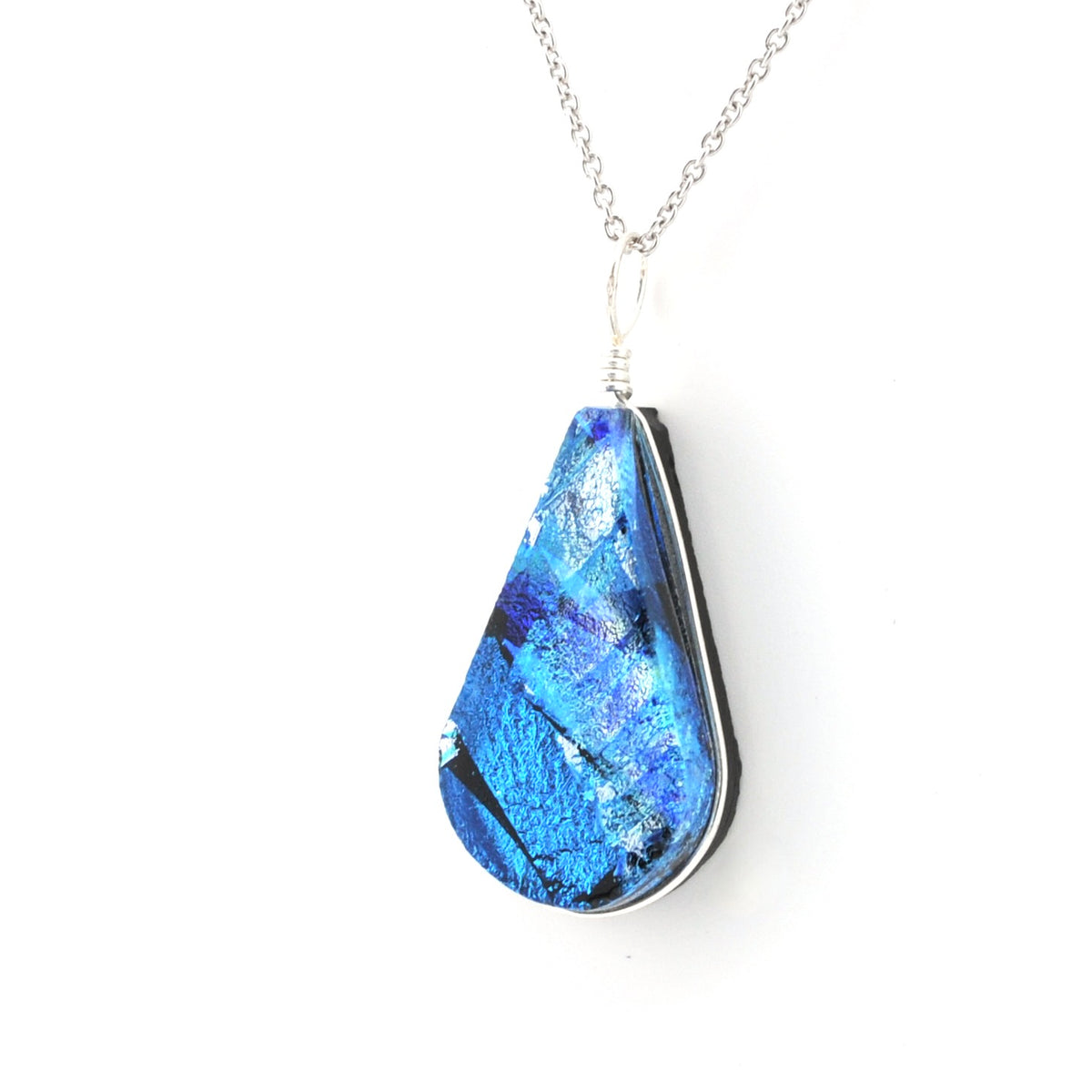 A silver teardrop pendant necklace featuring a textured, iridescent blue and silver glass piece with black inclusions, suspended from a delicate silver chain against a white background.
