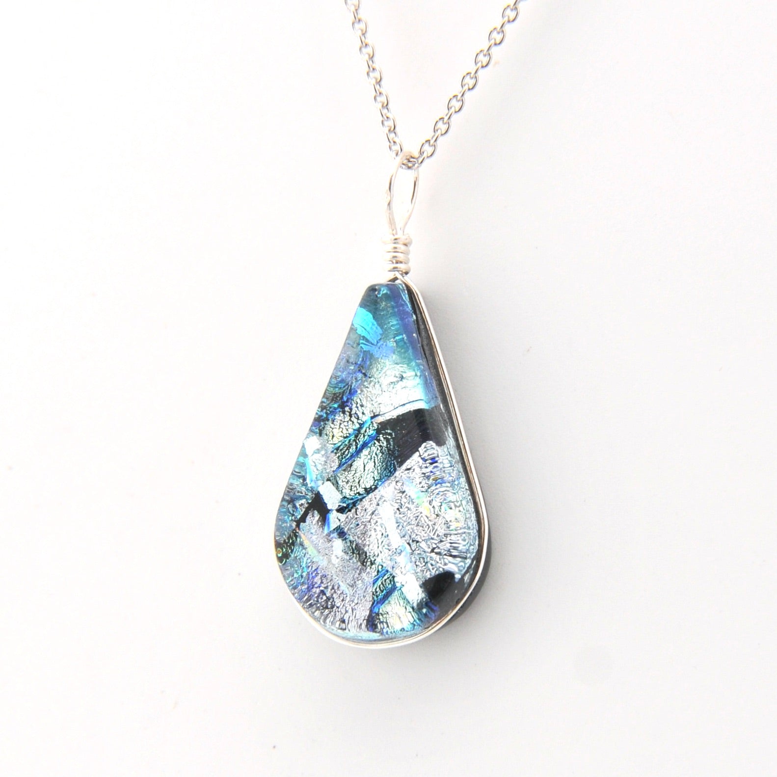 Teardrop-shaped pendant with a blue and silver design on a white background