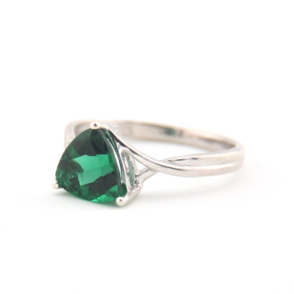 Silver ring with a heart-shaped green gemstone on a white background