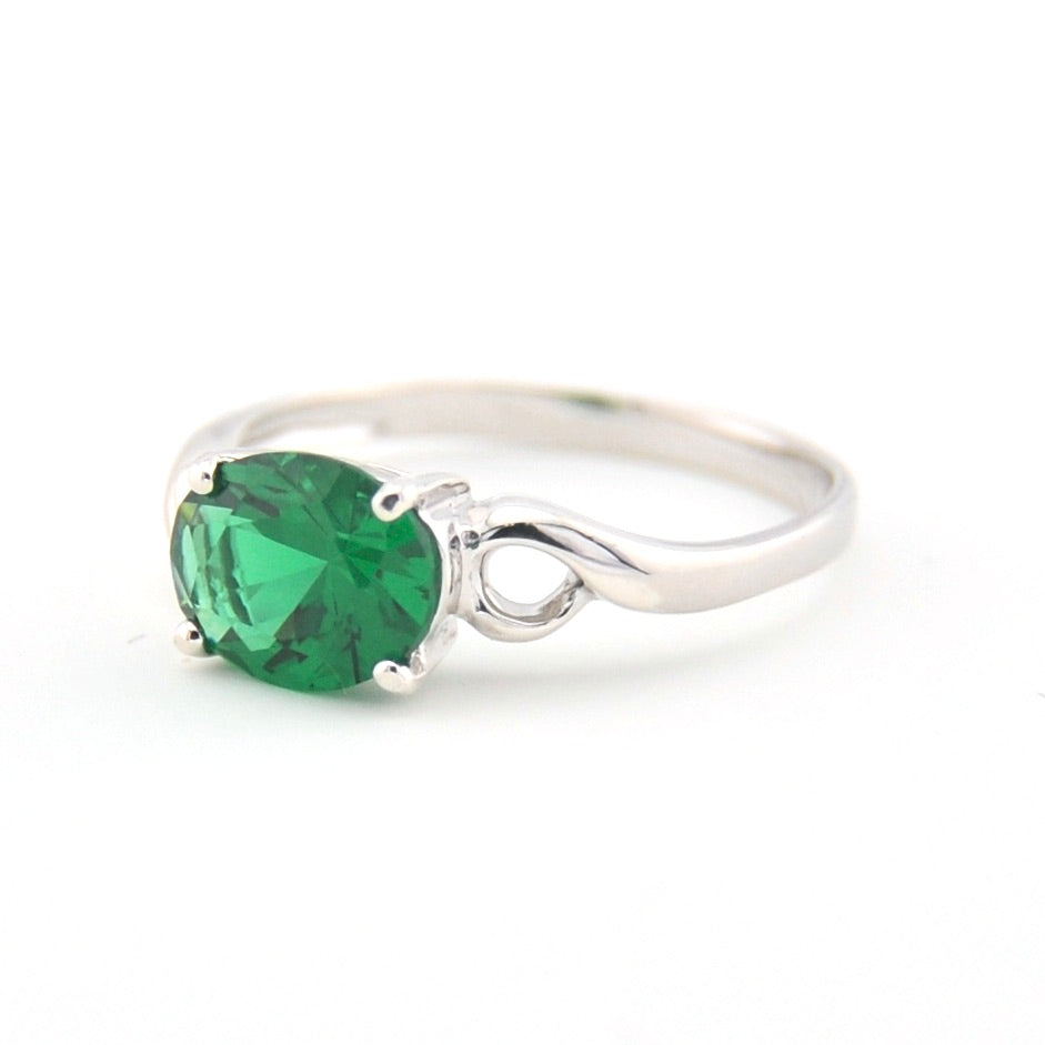 Silver ring with a green gemstone on a white background