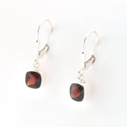 Pair of earrings with red gemstones on a white background
