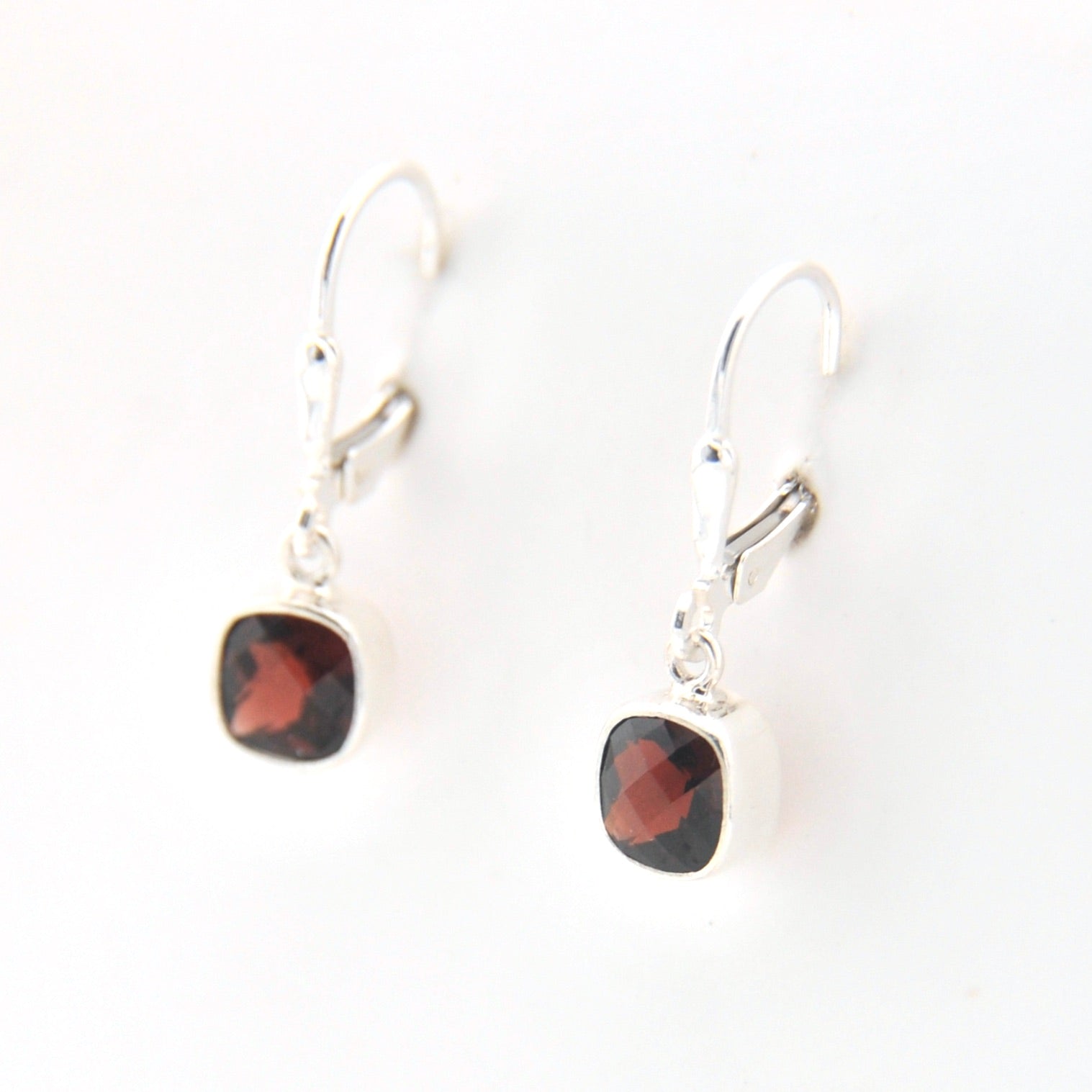 Pair of earrings with red gemstones on a white background