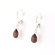Teardrop-shaped earrings with red stones on a white background
