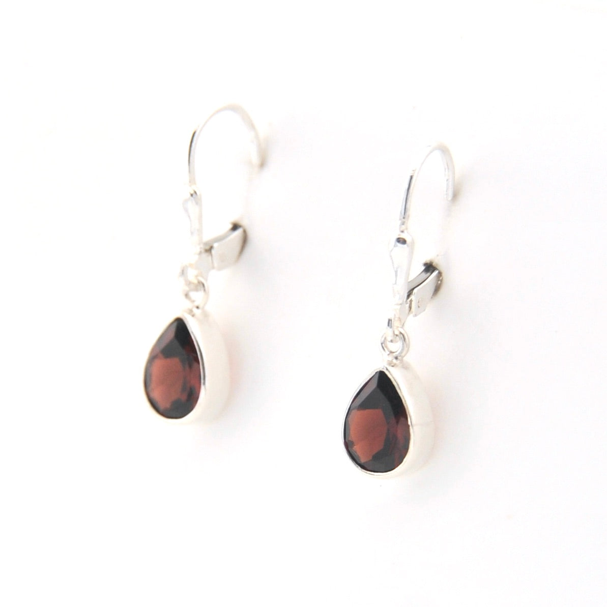 Teardrop-shaped earrings with red stones on a white background