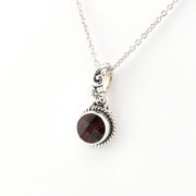 Silver necklace with a garnet pendant on a white background