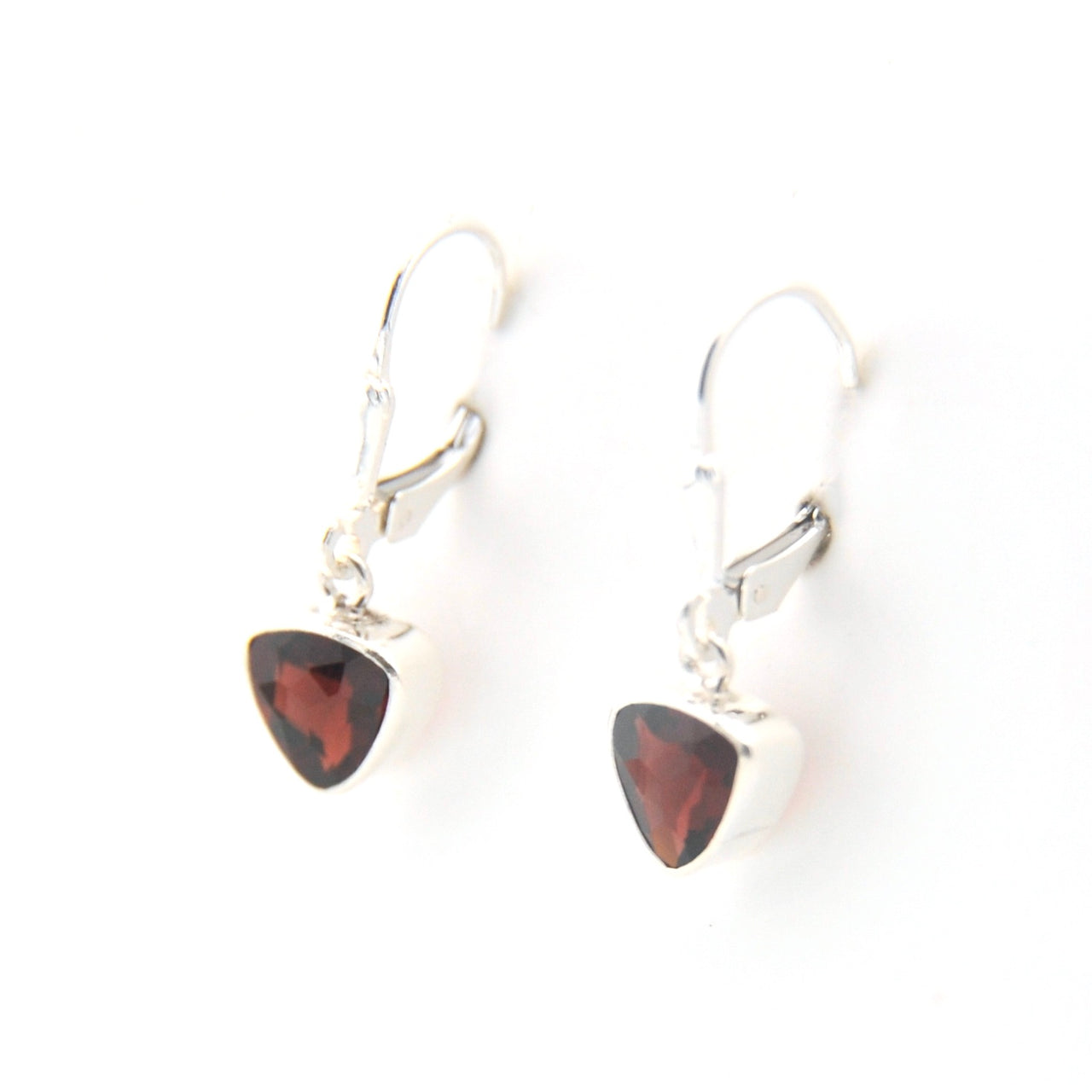 Silver earrings with red triangular stones on a white background