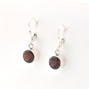 Pair of earrings with red gemstones on a white background