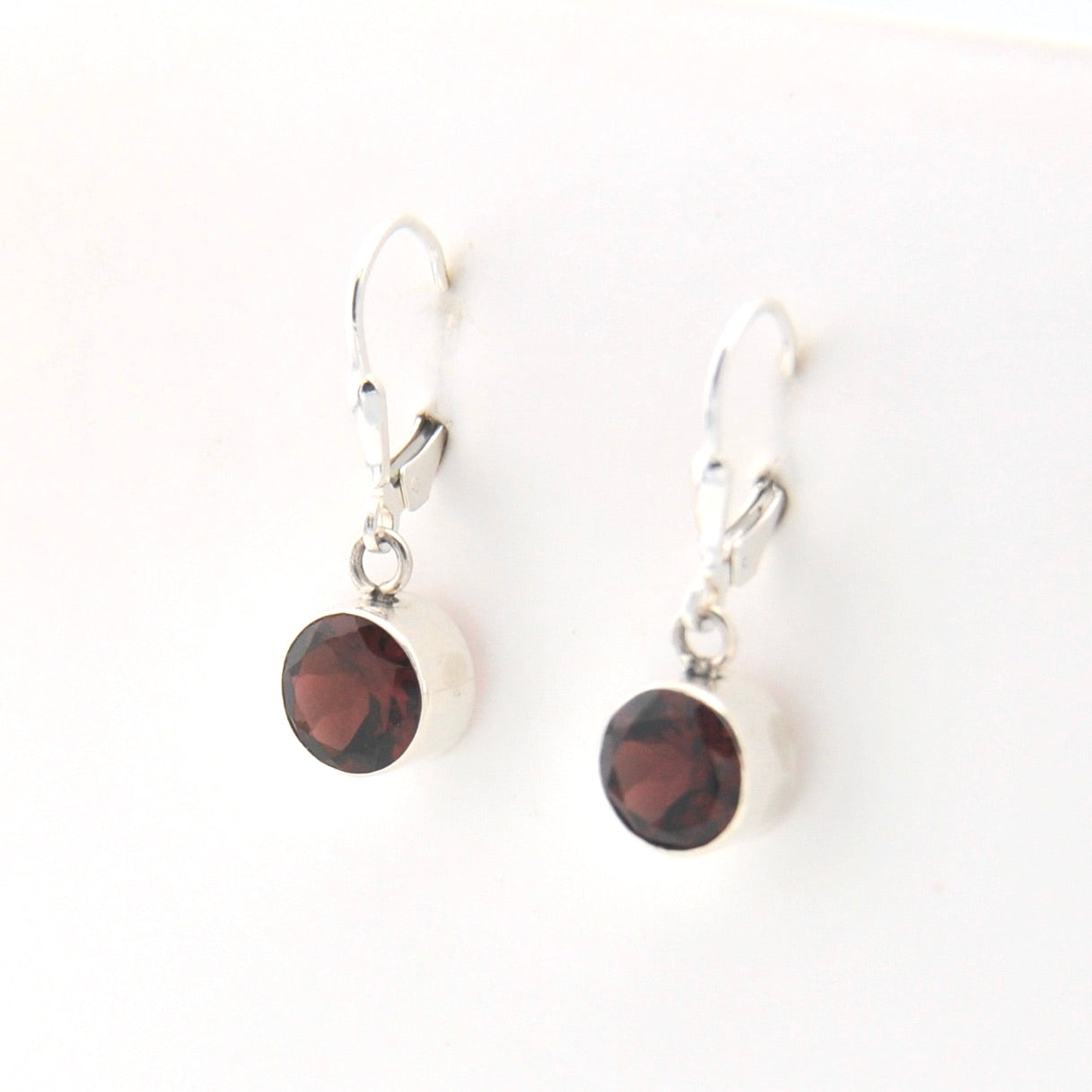 Pair of earrings with red gemstones on a white background