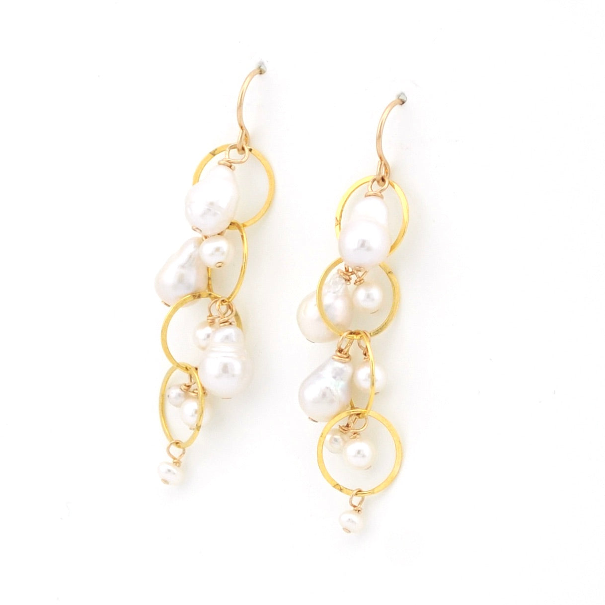 Pearl earrings with gold loops on a white background