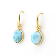 A pair of gold leverback drop earrings featuring oval light blue marbled stone cabochons, displayed on a clean white background.