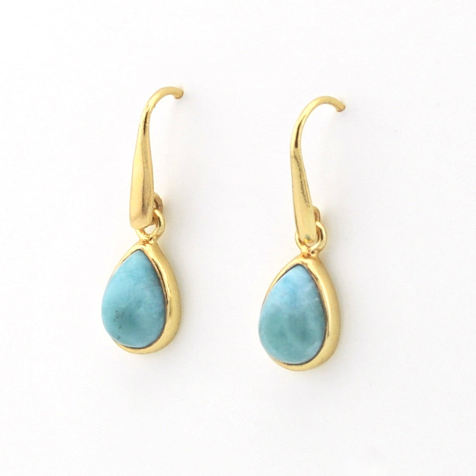 A pair of gold drop earrings with teardrop-shaped light blue larimar stones, shown on a plain white background.