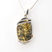 Pendant with amber stone and silver setting on a white background