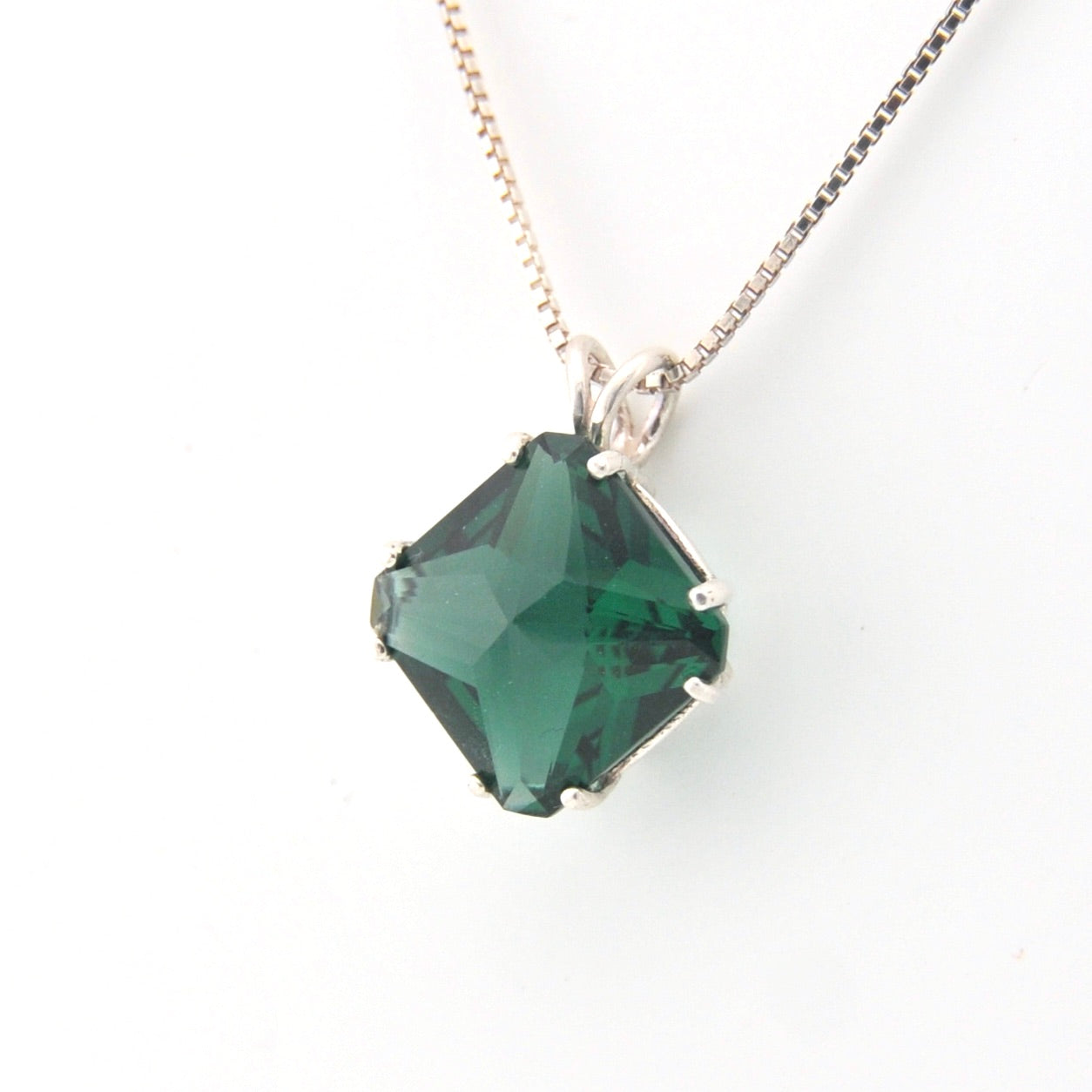 Necklace with a green gemstone pendant on a white background