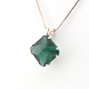Necklace with a green gemstone pendant on a white background