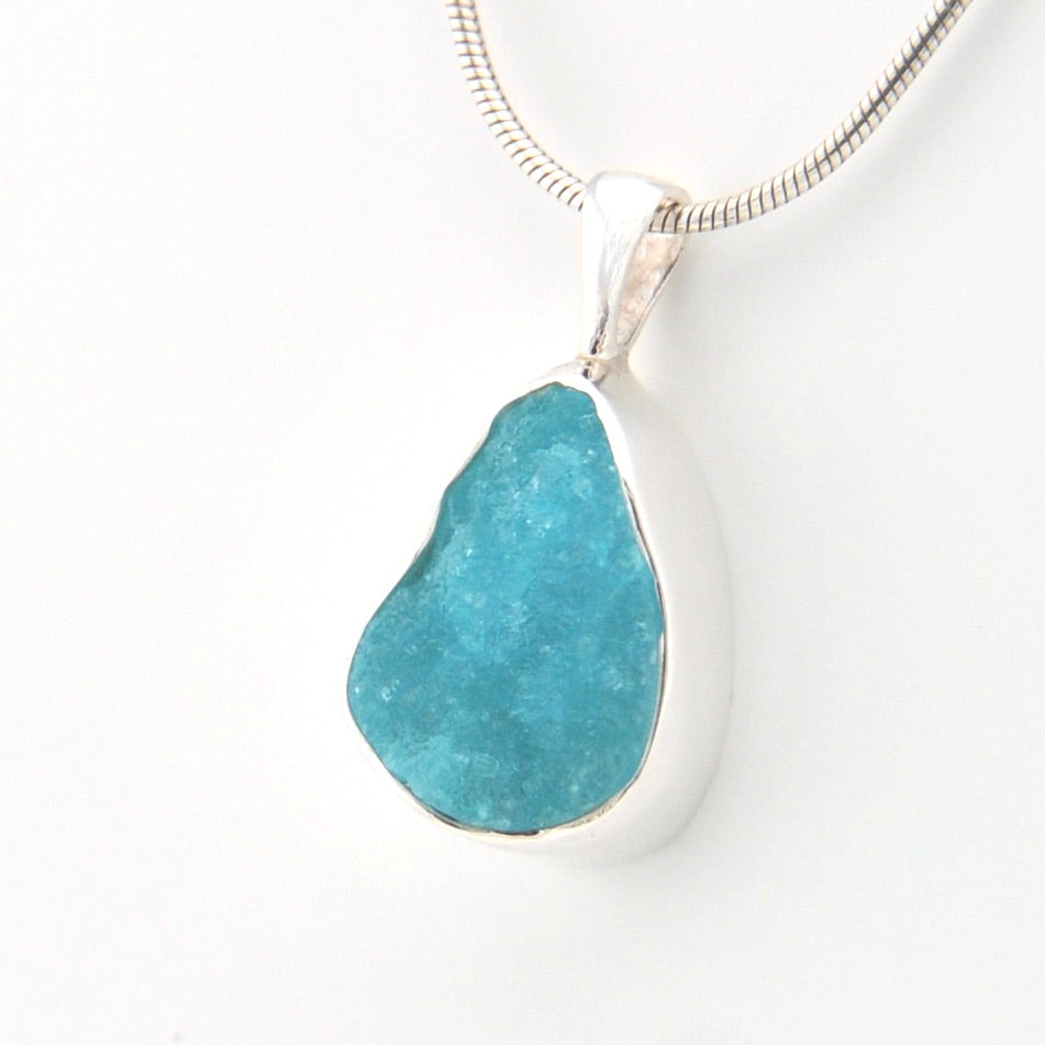 Teal pendant necklace on a white background