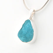 Teal pendant necklace on a white background