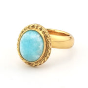 Gold ring with a turquoise stone on a white background
