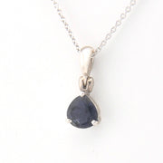 Silver pendant with a blue gemstone on a white background