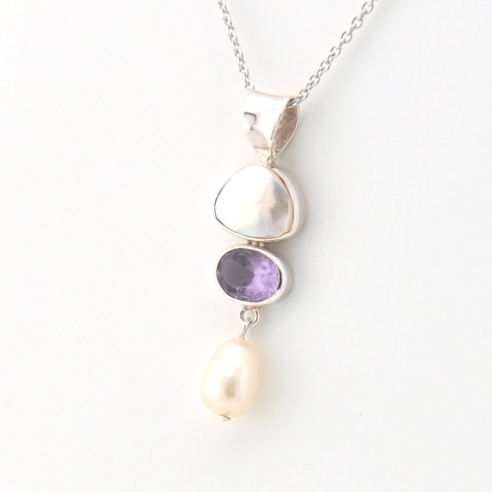 Necklace with a pendant featuring a pearl, amethyst, and silver design on a white background