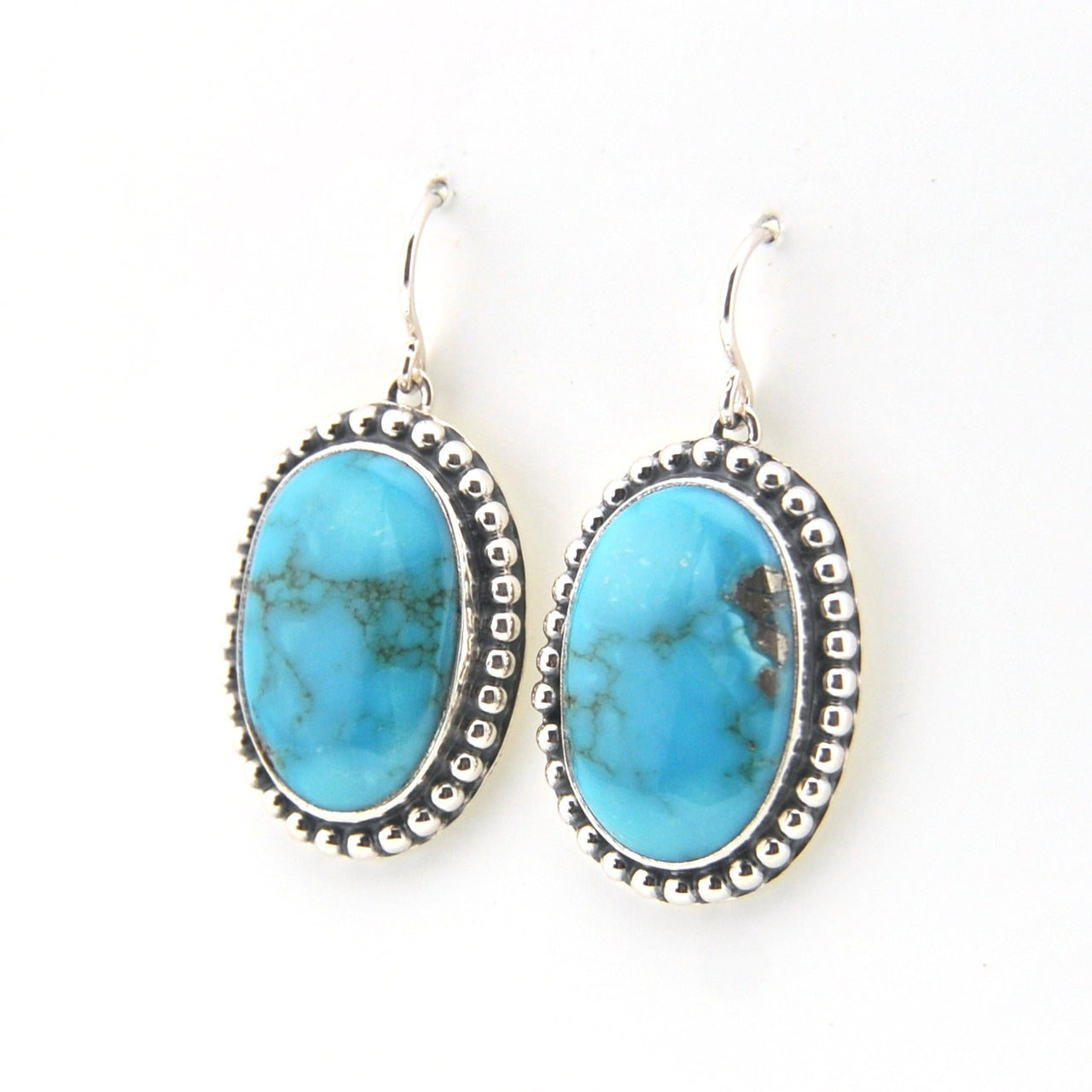 Turquoise oval earrings with silver detailing on a white background