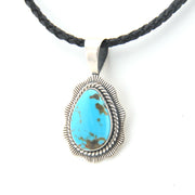 Turquoise pendant on a black cord against a white background