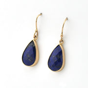 Gold earrings with blue teardrop-shaped stones on a white background