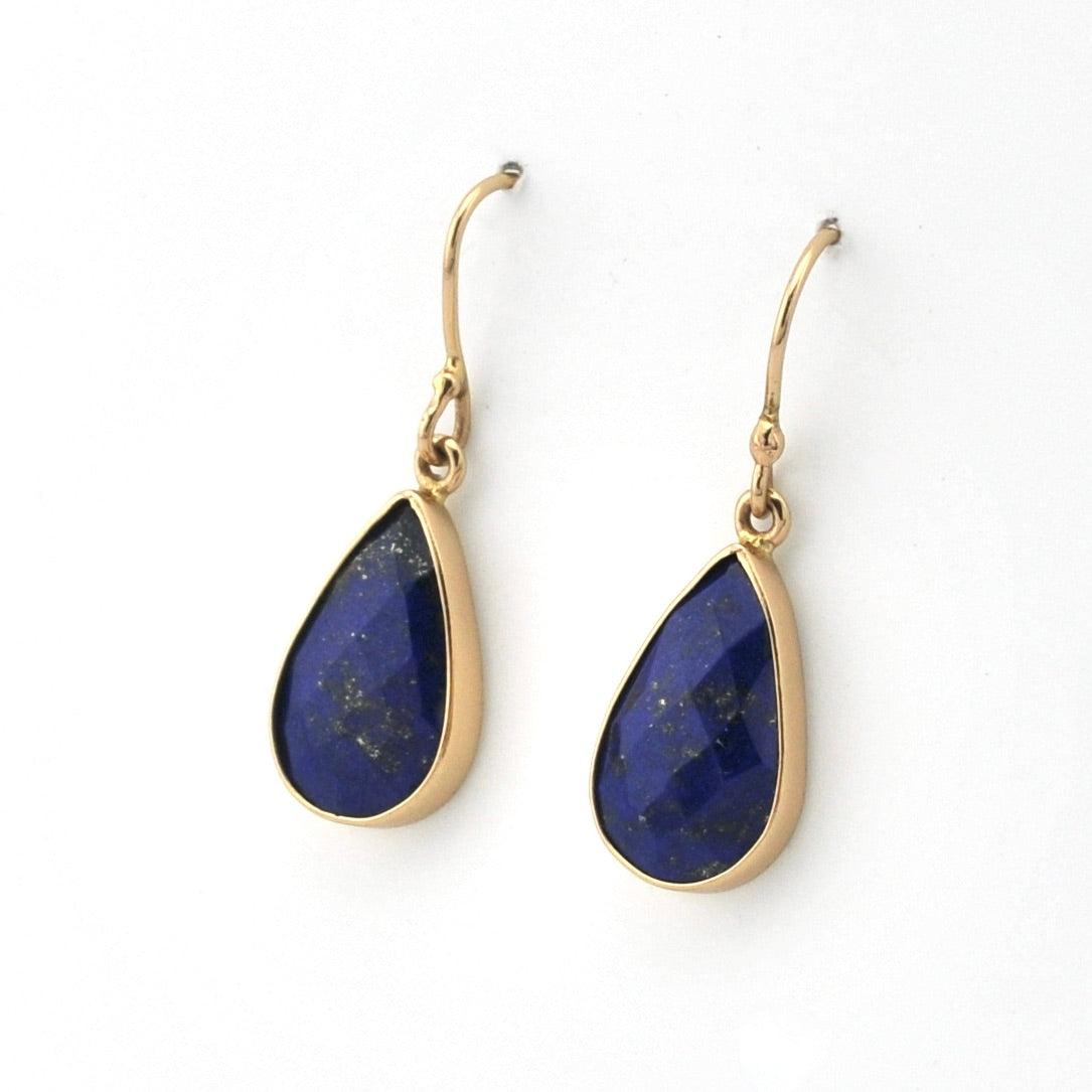 Gold earrings with blue teardrop-shaped stones on a white background