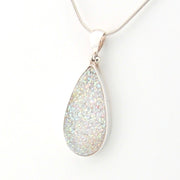 Teardrop-shaped silver pendant on a white background
