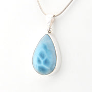 Teardrop-shaped blue pendant on a white background