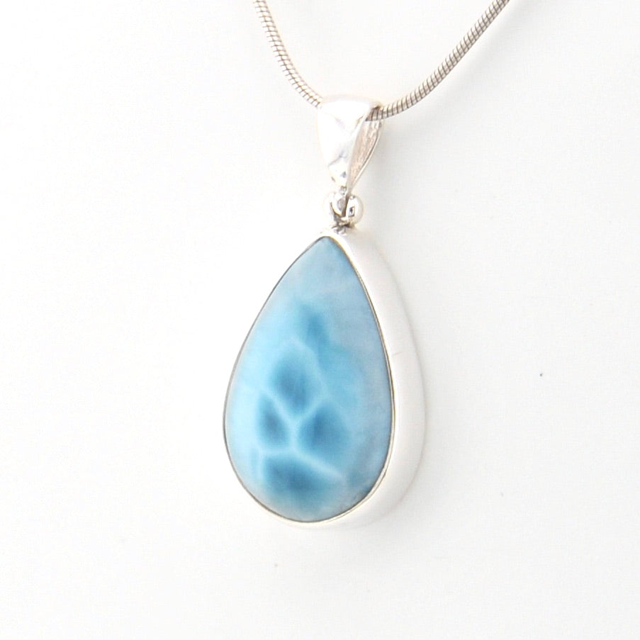 Teardrop-shaped blue pendant on a white background