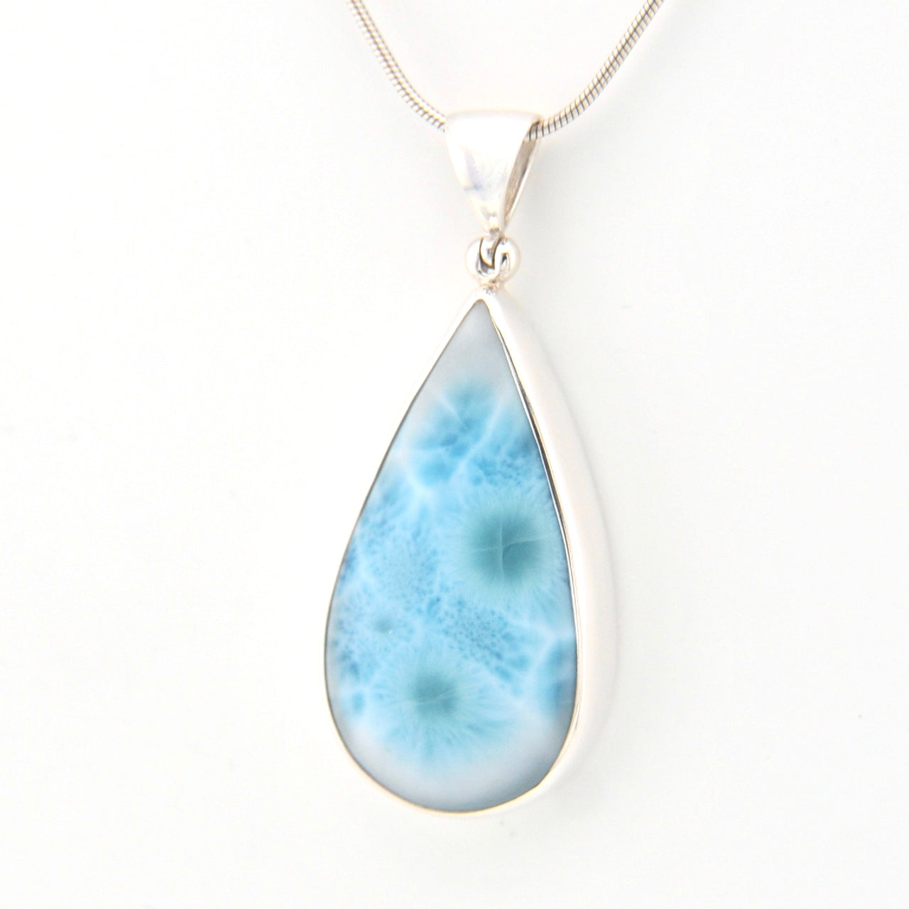 Teardrop-shaped larimar pendant on a white background