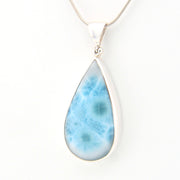 Teardrop-shaped larimar pendant on a white background