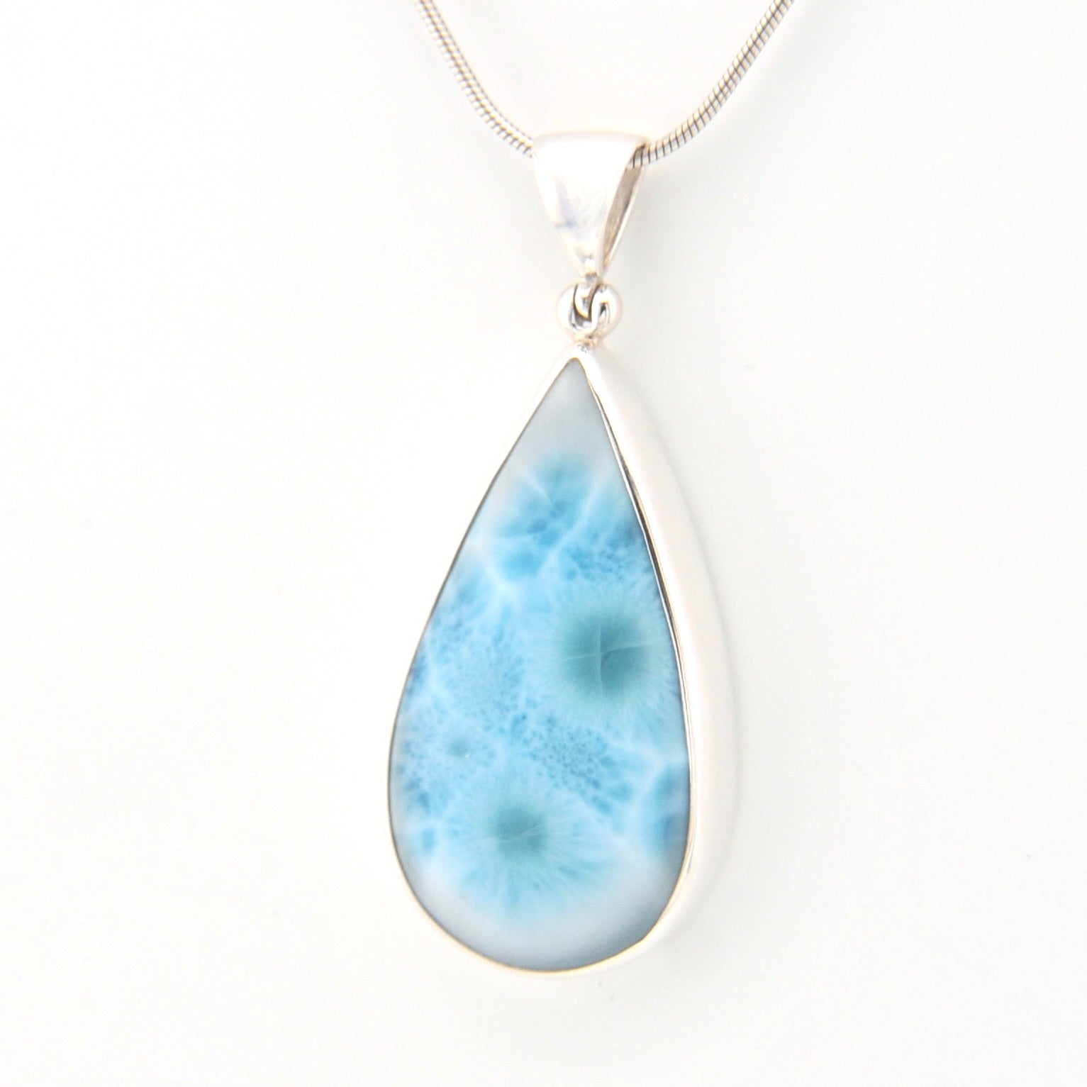 Teardrop-shaped larimar pendant on a white background