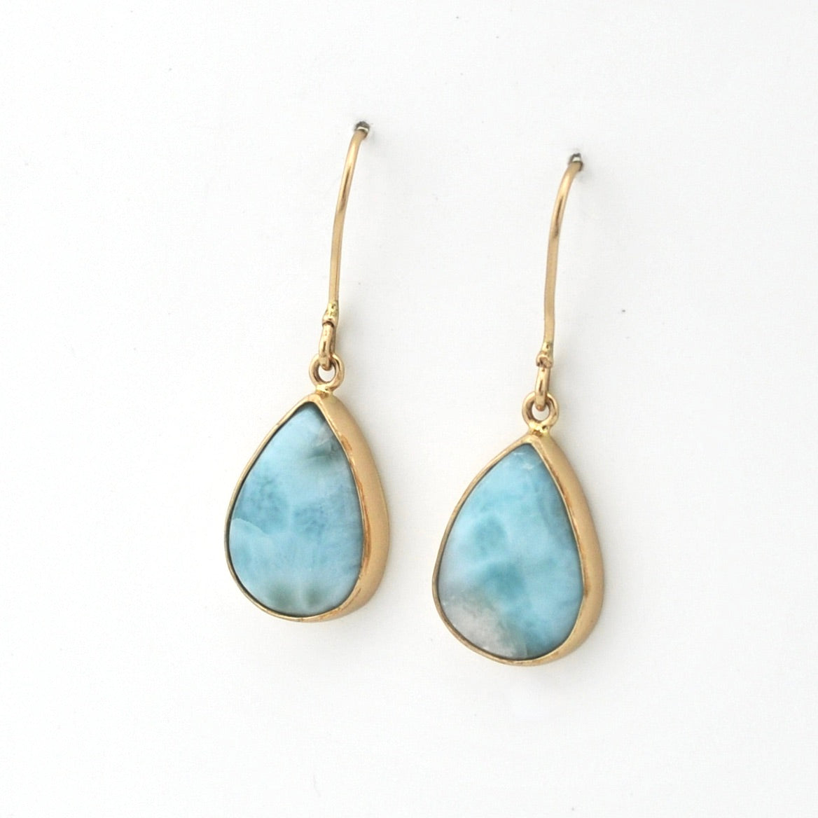 Teardrop-shaped earrings with gold hooks on a white background