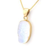 Gold necklace with a pendant featuring a white stone on a white background