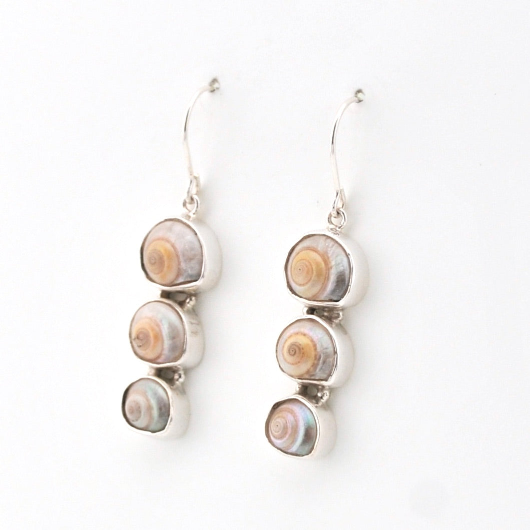 Pair of silver earrings with circular shell-like designs on a white background