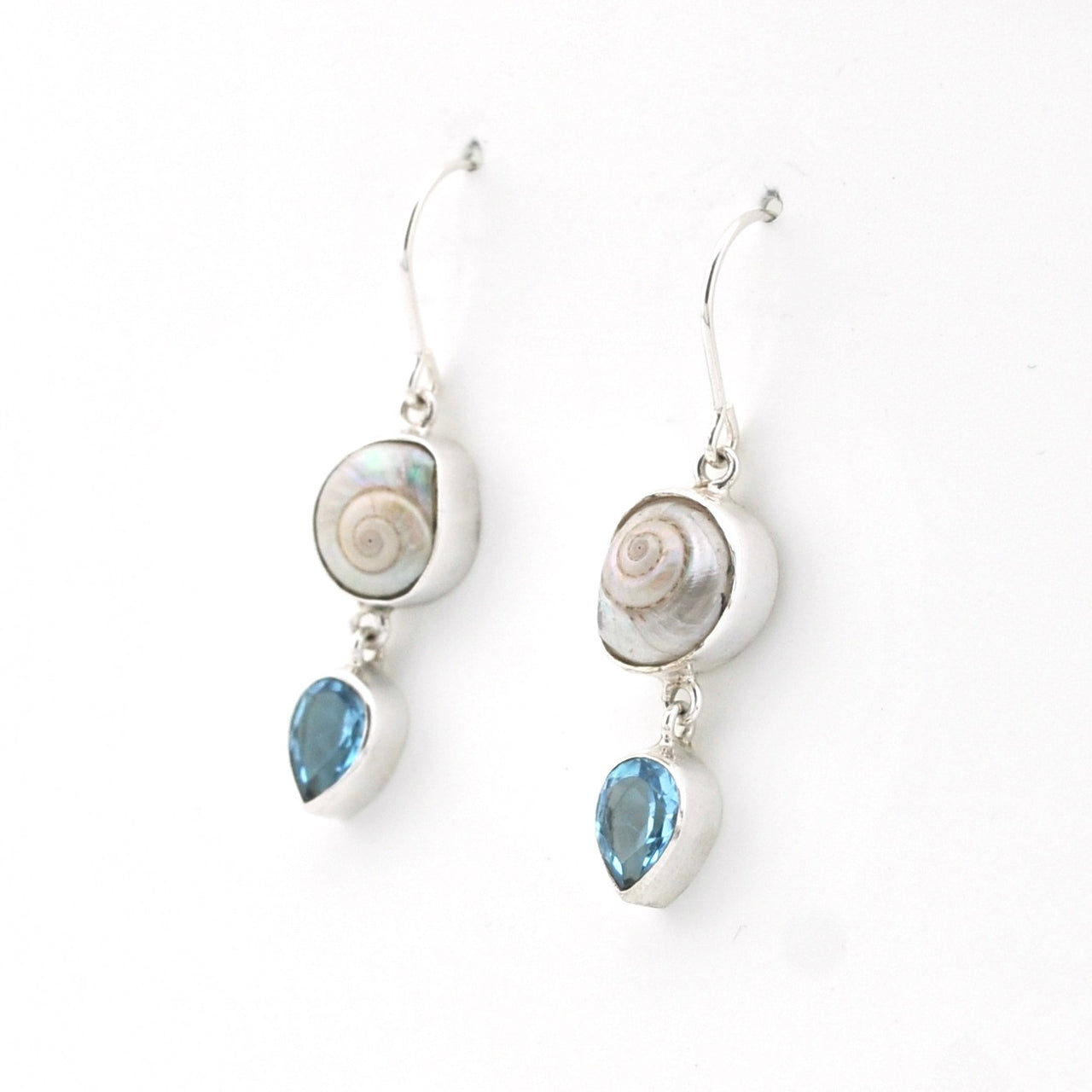 Silver earrings with shell and blue stone drops on a white background