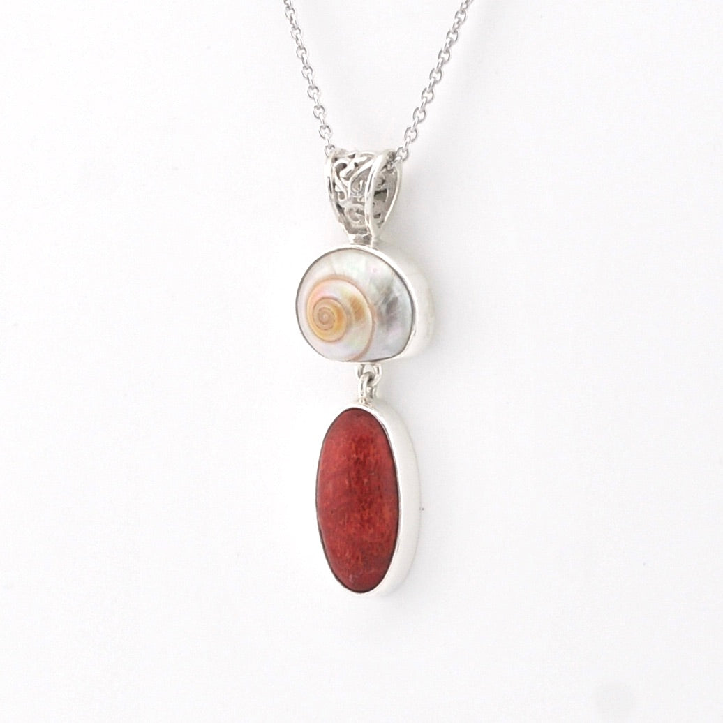 Necklace with a shell pendant and red stone on a white background
